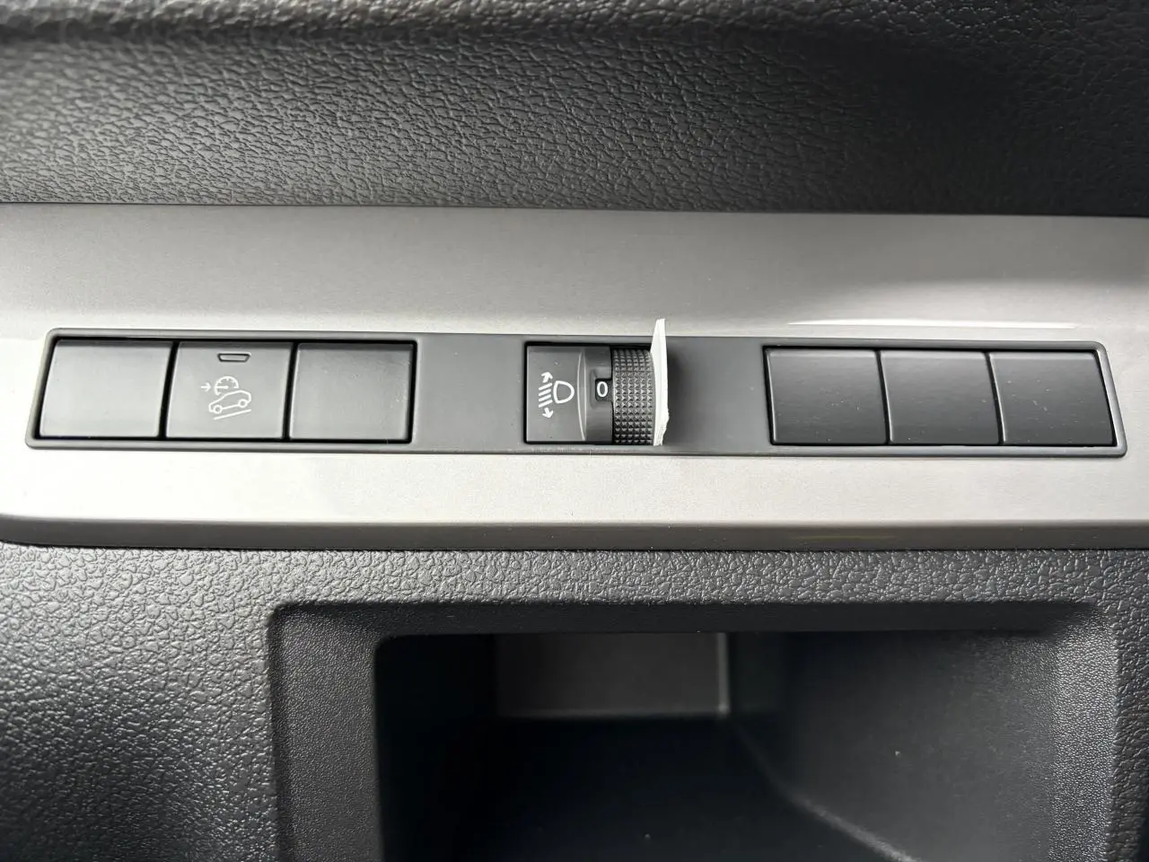 Gros plan sur les commandes de réglage des phares et de l’aide à la descente du Peugeot Expert Fourgon blanc Icy.