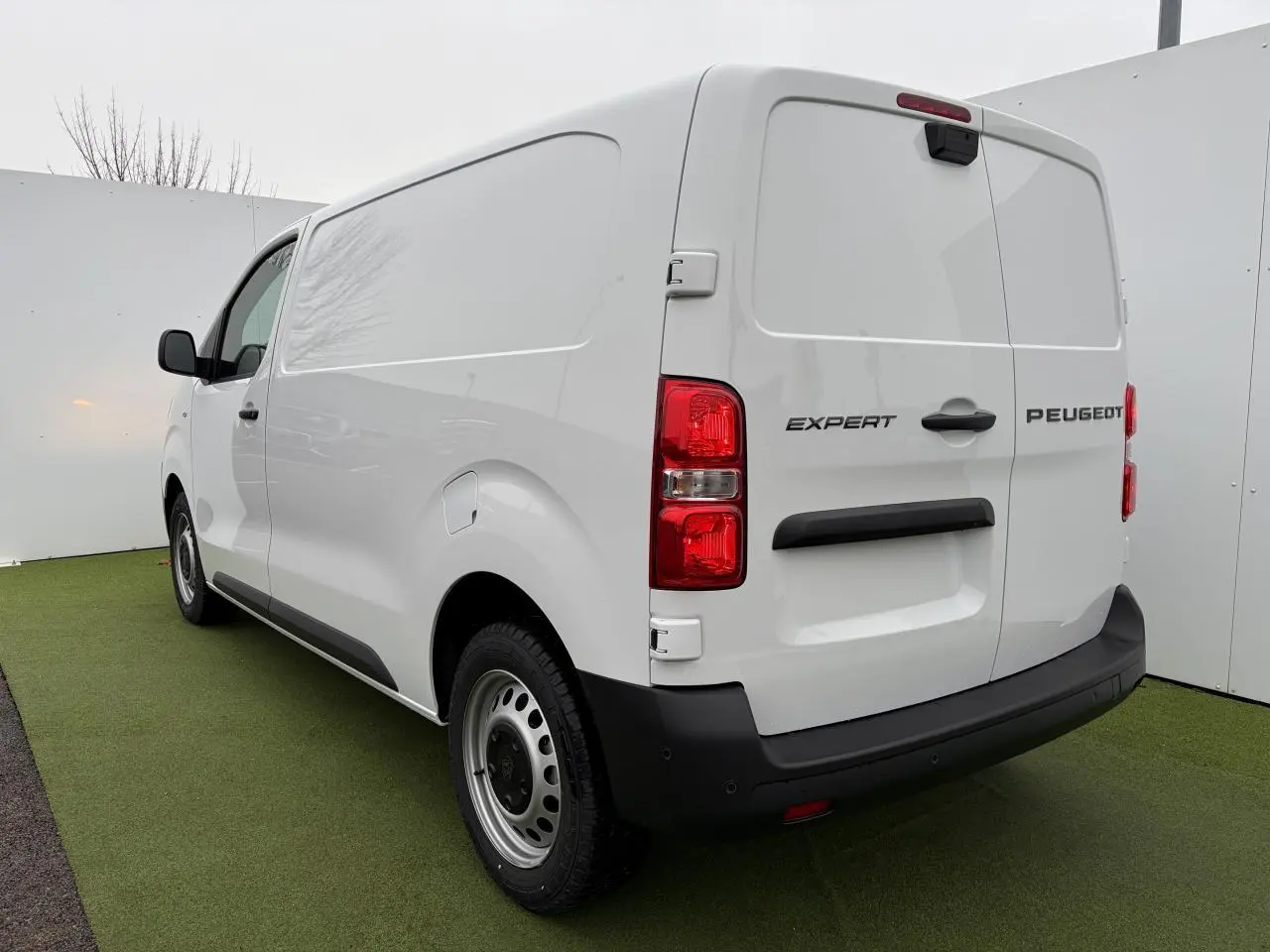 Vue 3/4 arrière droite du Peugeot Expert Fourgon blanc Icy avec portes battantes arrière et jantes tôle grises.