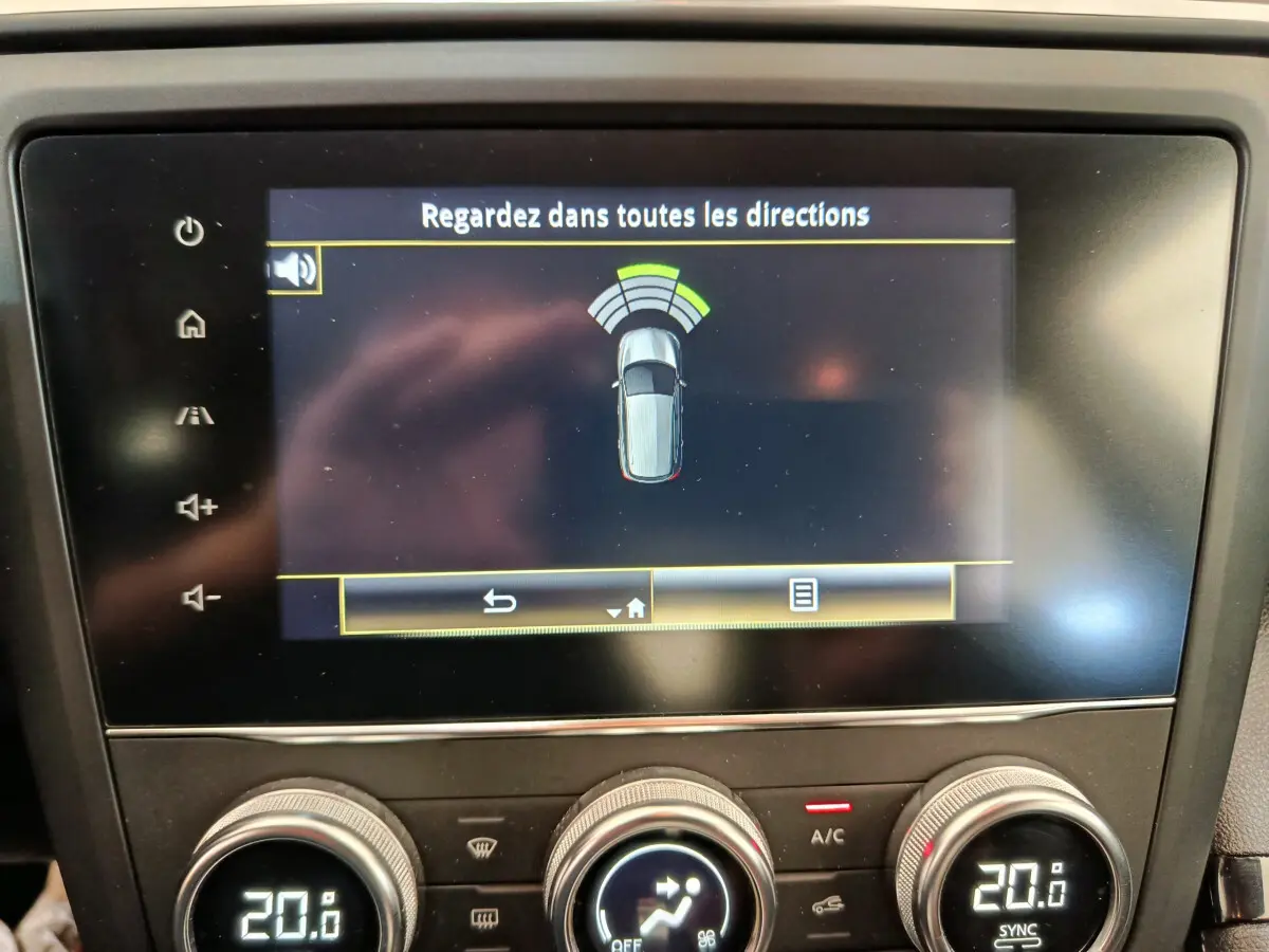 Écran tactile central du Renault Kadjar 2022 affichant l’aide au stationnement avec commandes de climatisation digitales en dessous.