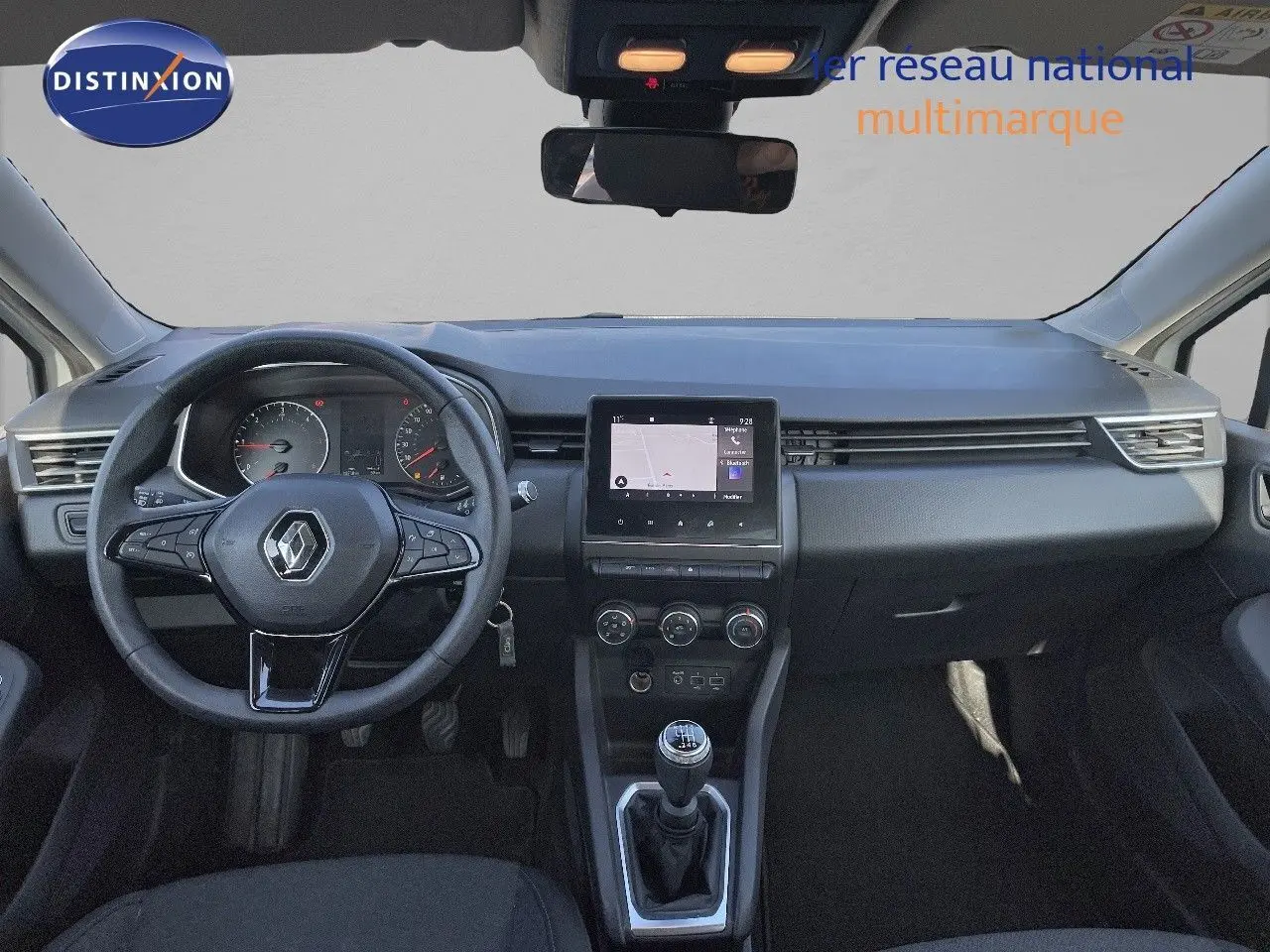 Vue frontale de l'habitacle d'une Renault Clio Société blanche avec tableau de bord moderne et écran tactile central.