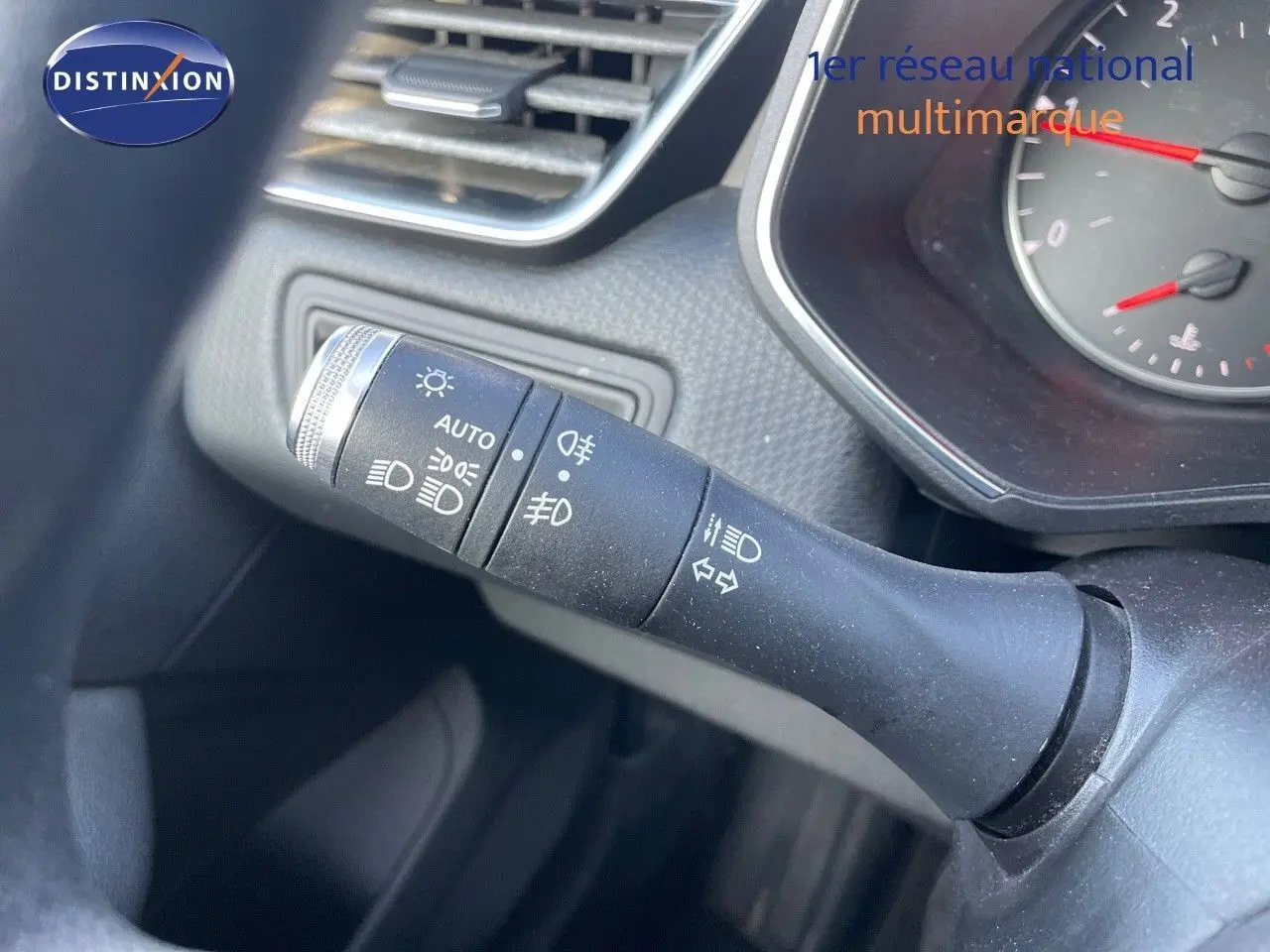 Gros plan sur la commande des phares et clignotants dans l'habitacle d'une Renault Clio Société blanche.