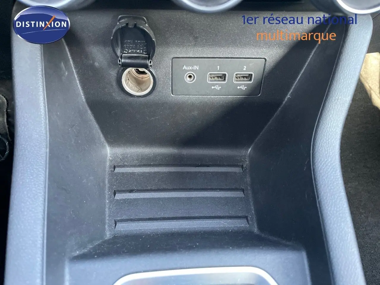 Vue rapprochée de la console centrale noire avec prises USB et prise auxiliaire du Renault Clio Société blanc glacier.