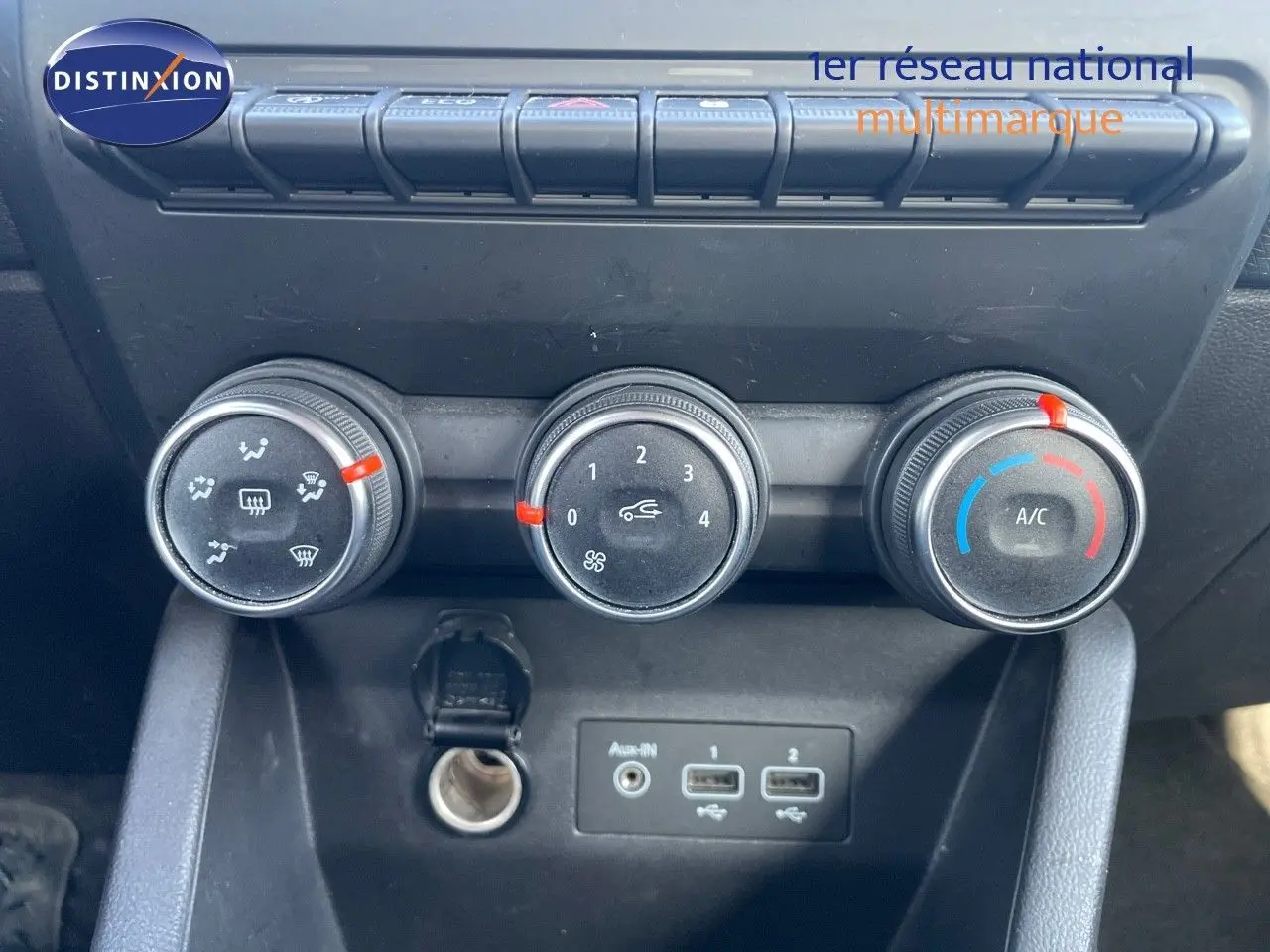 Gros plan sur les commandes de climatisation et les ports USB d'une Renault Clio Société blanc glacier, intérieur noir.