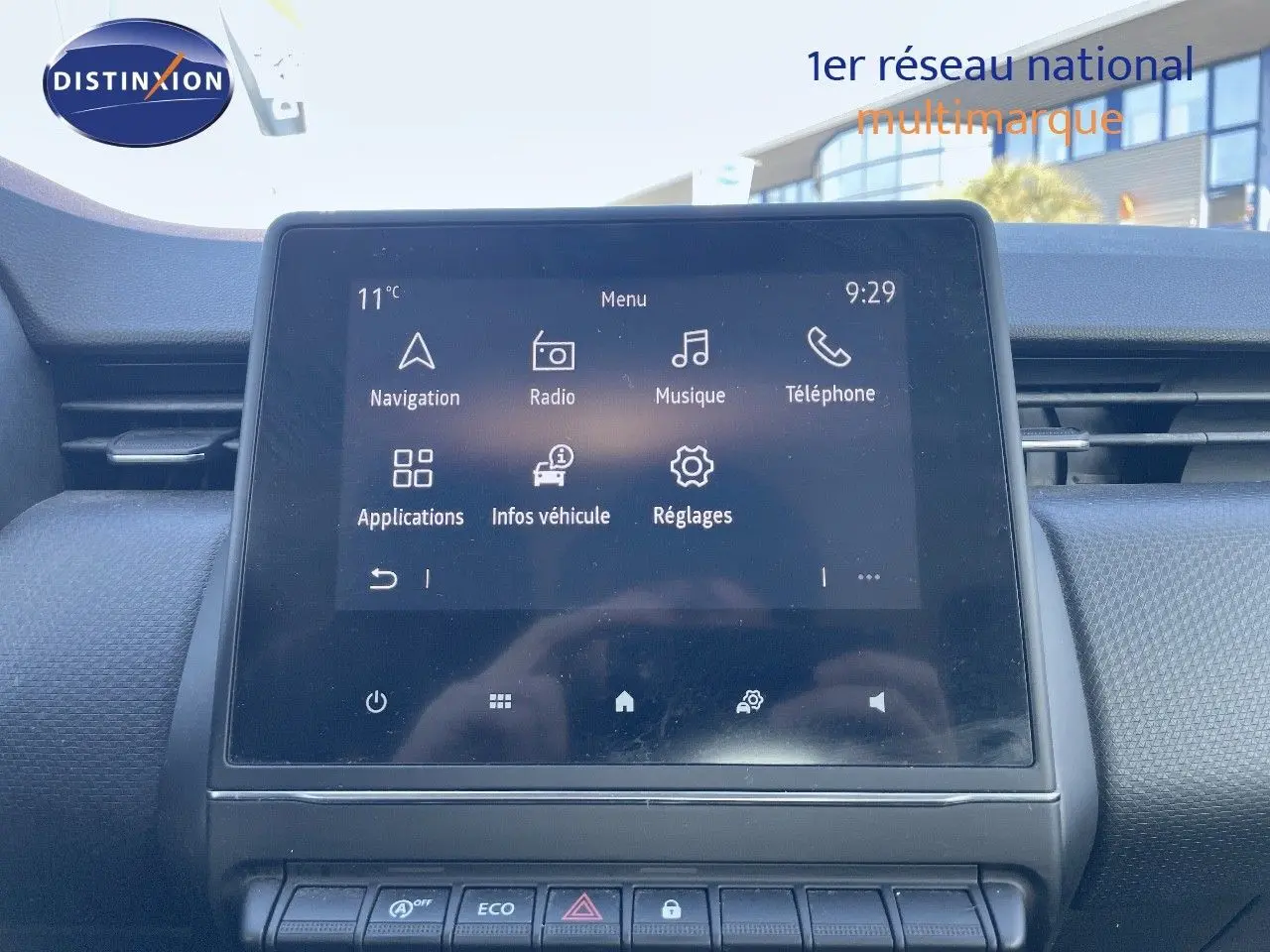 Écran tactile central allumé du tableau de bord d'une Renault Clio Société blanche, vue intérieure frontale.