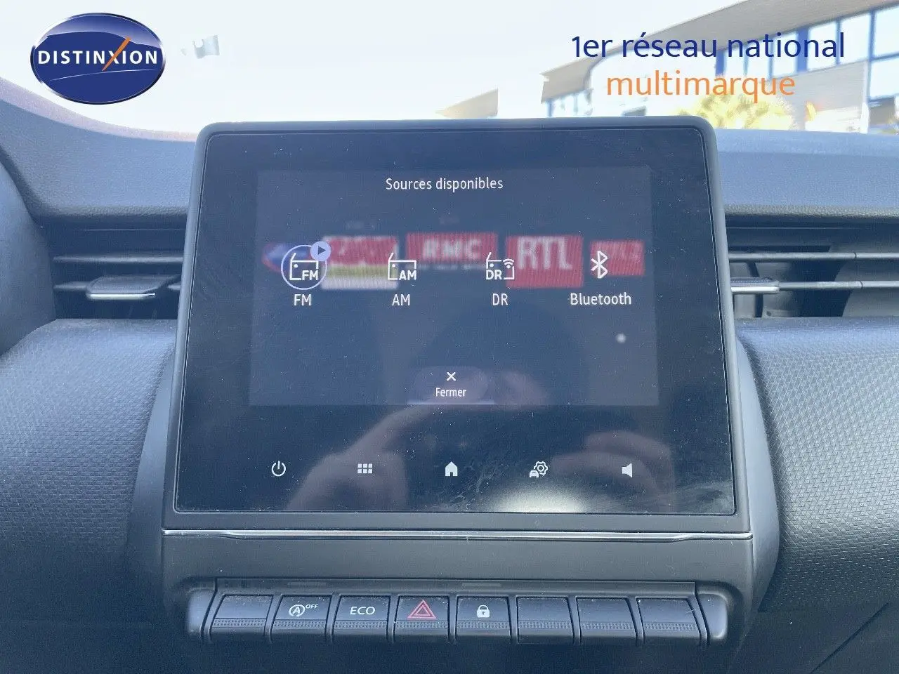 Écran tactile central affichant les sources audio dans l'habitacle d'une Renault Clio Société blanche.