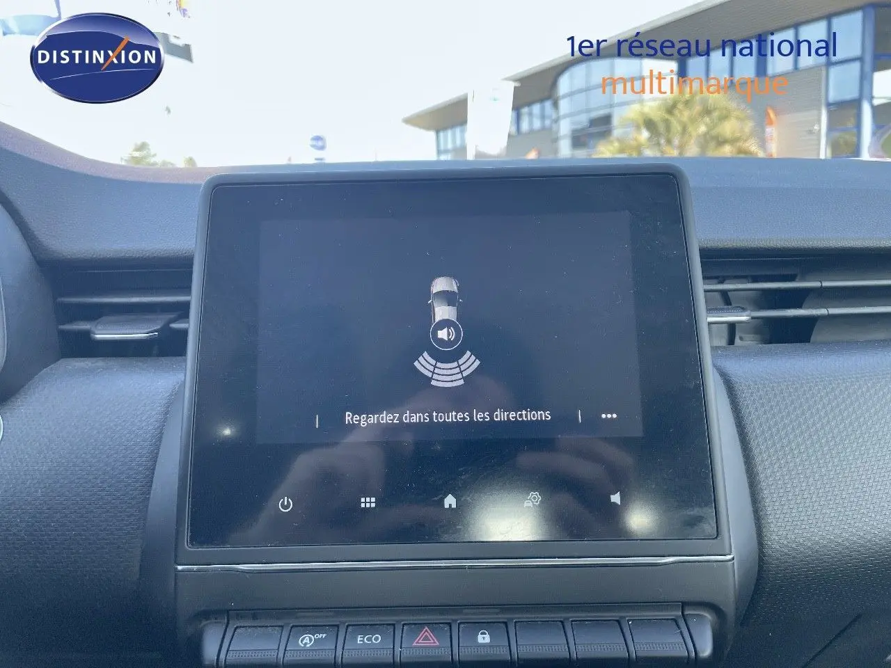 Écran tactile central du tableau de bord de la Renault Clio Société blanc glacier, affichant l'alerte de capteurs de proximité.