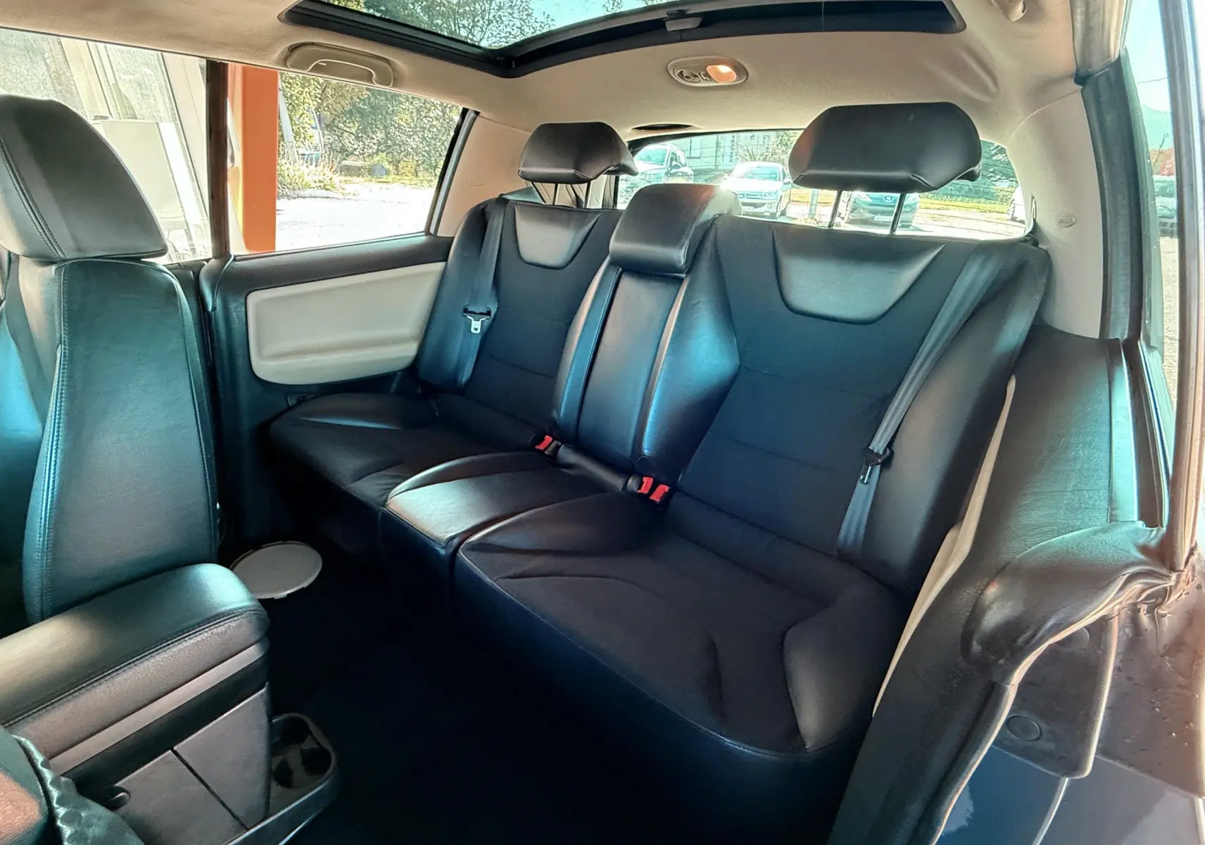 Banquette arrière en cuir noir vue côté droit du Renault Avantime gris avec toit ouvrant panoramique visible.