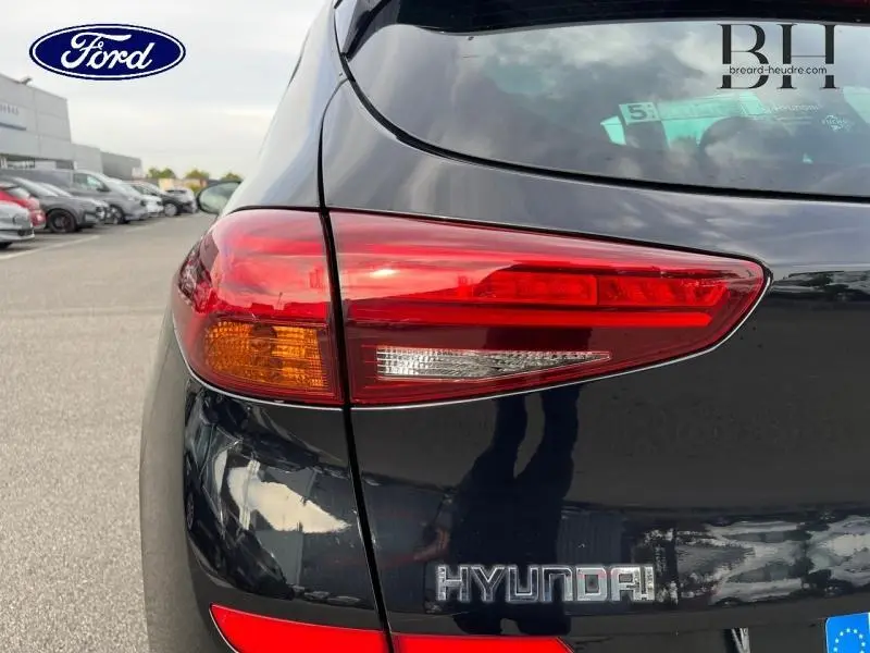 Feu arrière droit rouge et orange sur Hyundai Tucson Phantom Black Métal vu de près, arrière du véhicule visible.