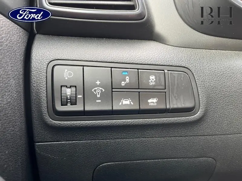 Gros plan sur les commandes de sécurité et d'éclairage du tableau de bord d'un Hyundai Tucson Phantom Black 2020.