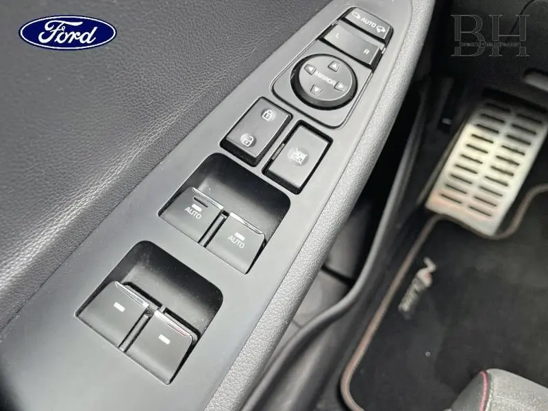 Gros plan sur les commandes de lève-vitres et rétroviseurs côté conducteur d'un Hyundai Tucson Phantom Black Métal.