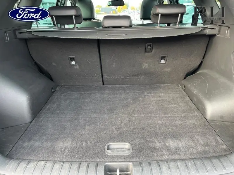 Coffre spacieux vu de l'arrière d'un Hyundai Tucson Phantom Black Métal avec banquette arrière et cache-bagages noirs.