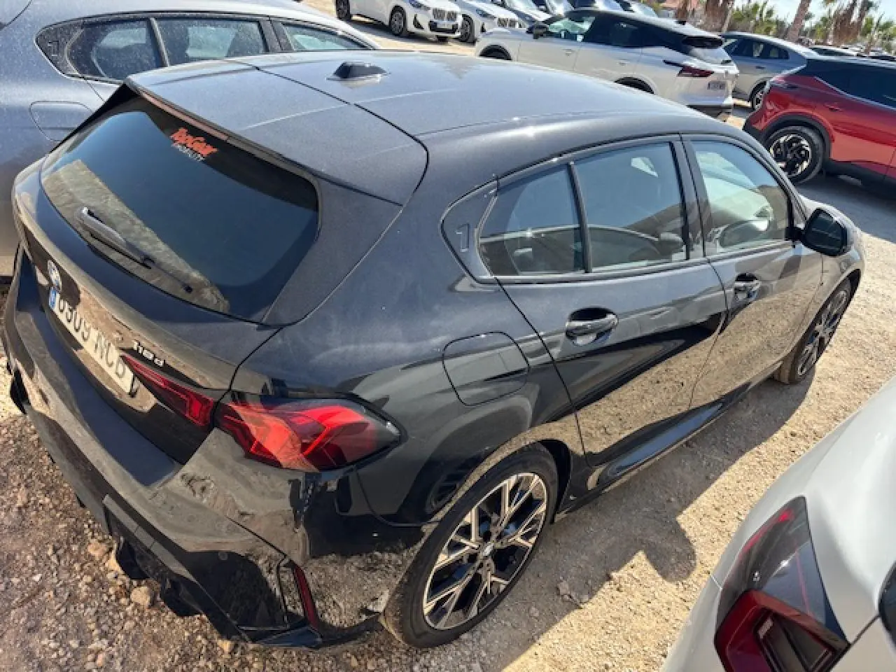 BMW Série 1 118d noir métal vue 3/4 arrière droit, jantes alliage 18 pouces et feux arrière LED visibles