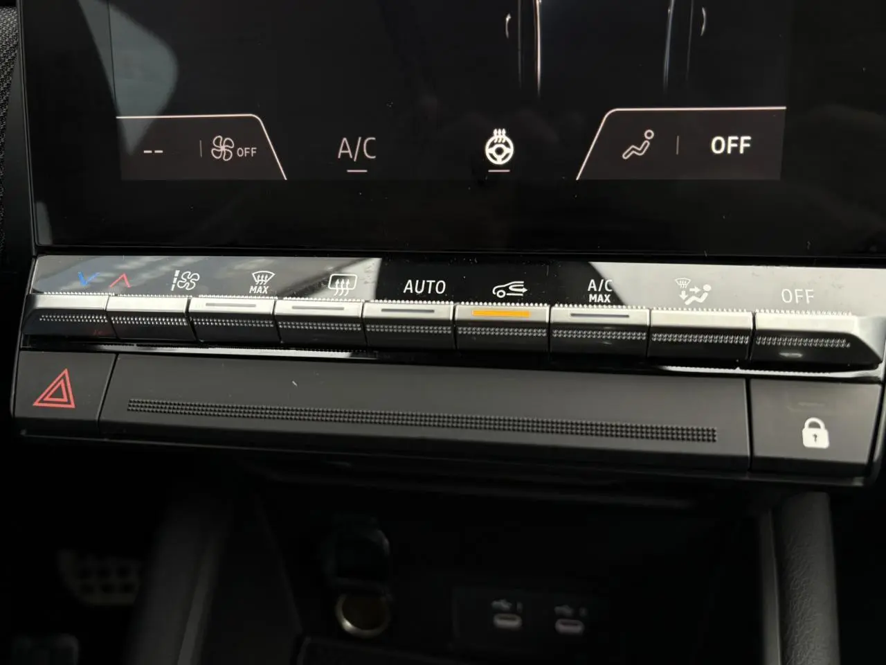 Gros plan sur la console centrale du Renault Captur 2025, boutons de climatisation et écran tactile noir.