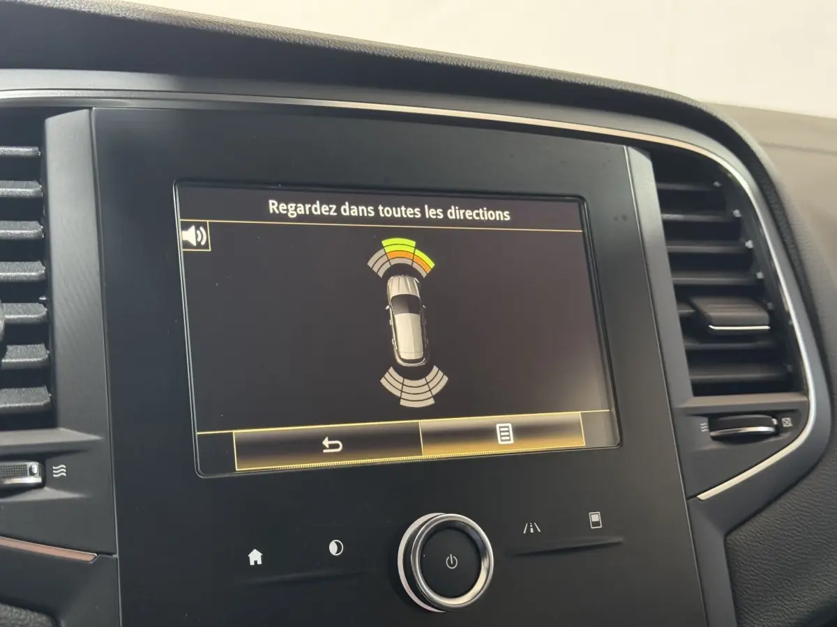 Écran tactile central de la Renault Mégane Business gris clair affichant l'alerte de détection d'obstacles.