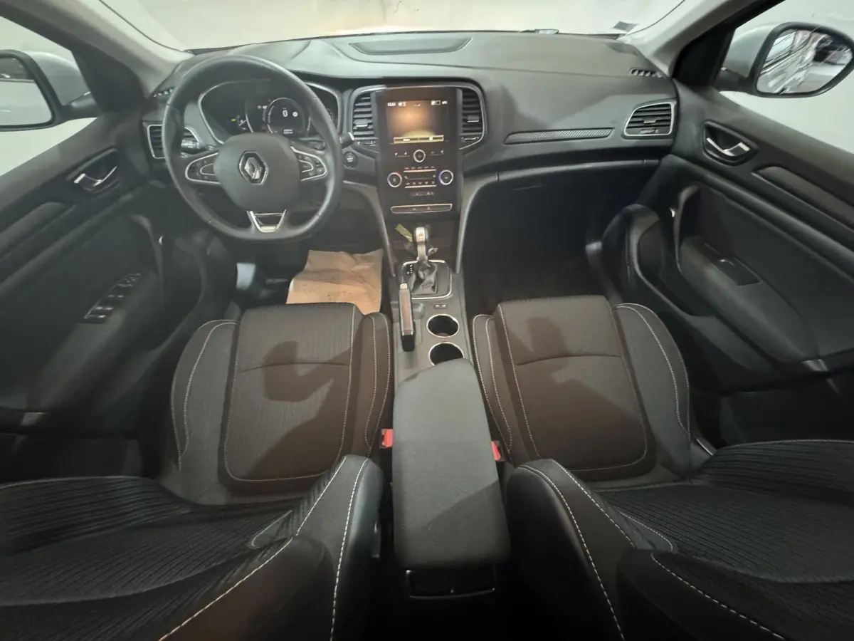 Intérieur noir de la Renault Mégane Business 2019, vue avant centrée sur le tableau de bord et le volant cuir multifonctions.