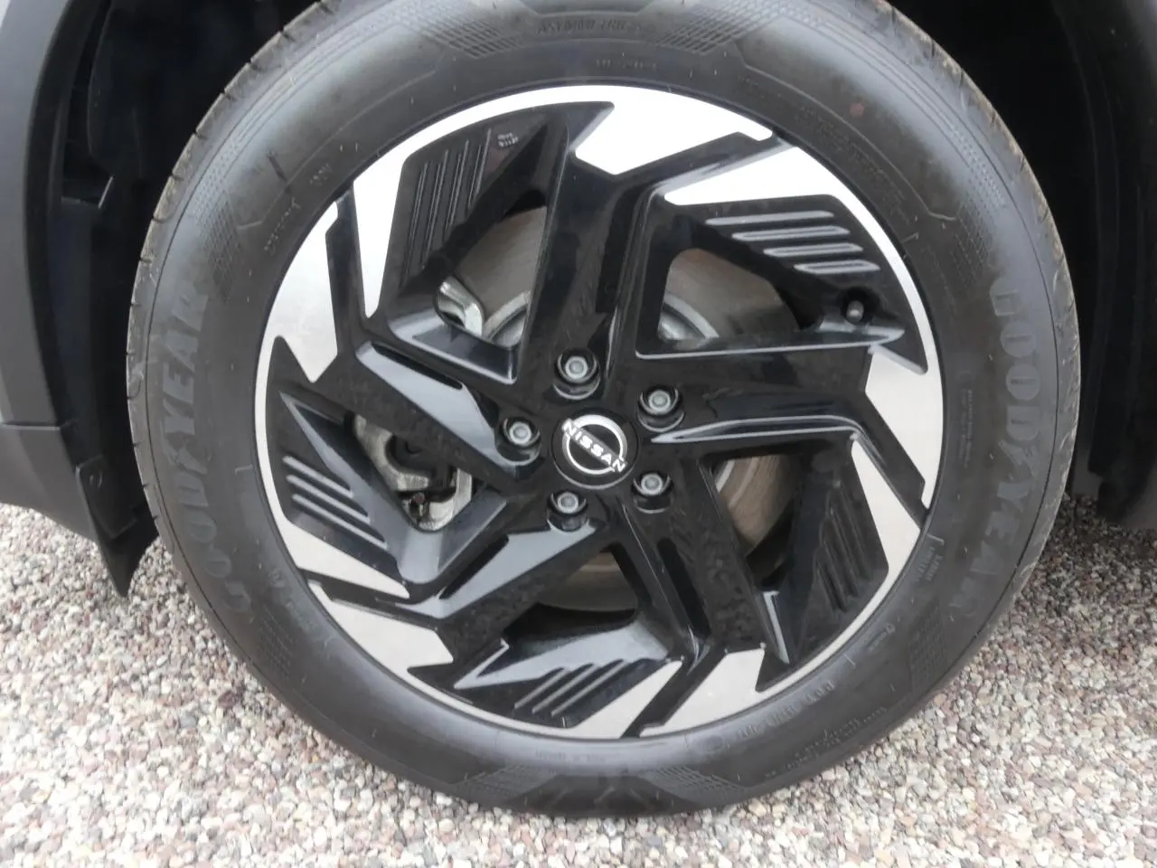 Gros plan sur la jante alliage 18 pouces bicolore noire et argentée du Nissan Qashqai gris métallisé.