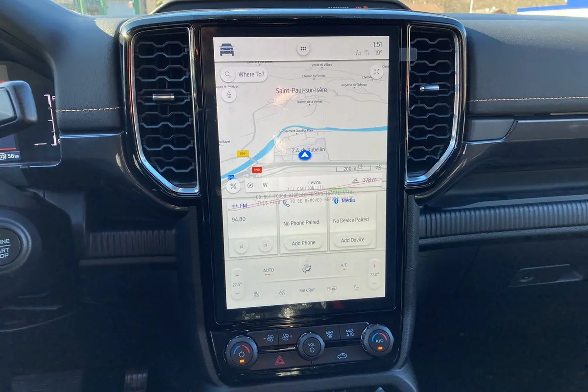 Vue rapprochée de la console centrale noire du Ford Ranger 2025 avec écran tactile GPS vertical et commandes climatisation.