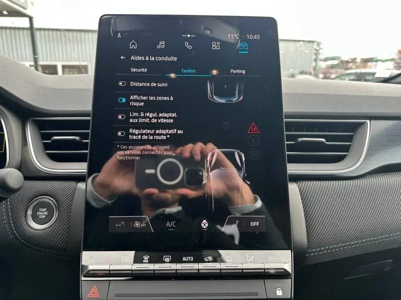 Écran tactile central du Renault Captur 2026 en gros plan, avec commandes d’aides à la conduite visibles.