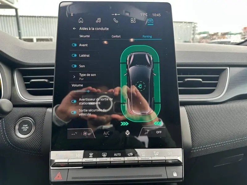 Écran tactile central du Renault Captur 2026 affichant les aides à la conduite, avec tableau de bord noir et bouton Start/Stop visible.