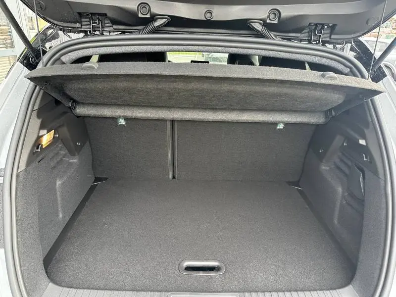 Coffre ouvert vu de l'arrière du Renault Captur 1.8 E-Tech hybride 2026, intérieur noir avec cache-bagages relevé.