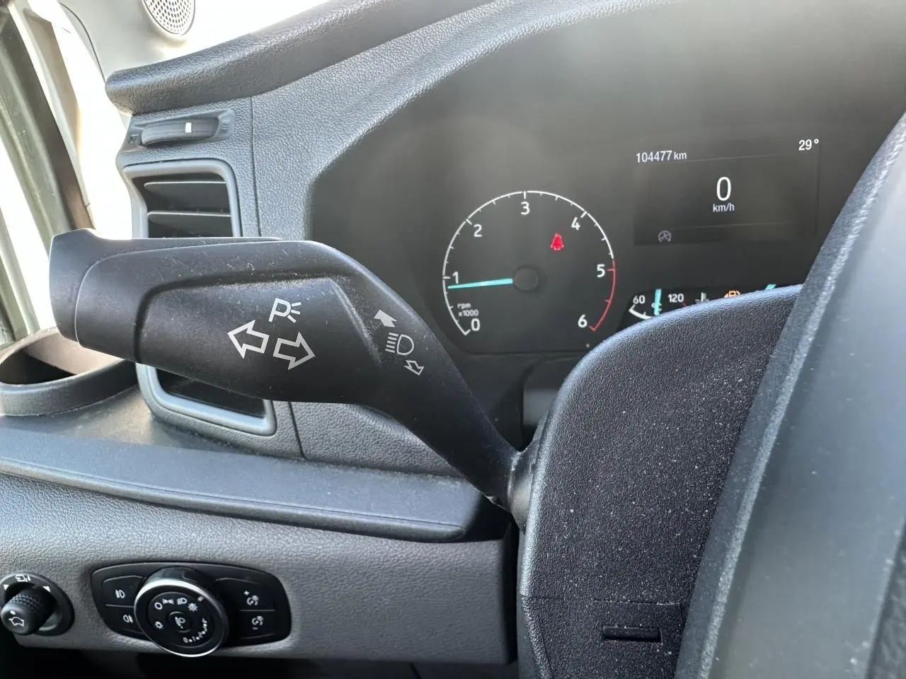 Gros plan sur la manette de clignotants et le tableau de bord numérique du Ford Transit Fourgon blanc de 2020.