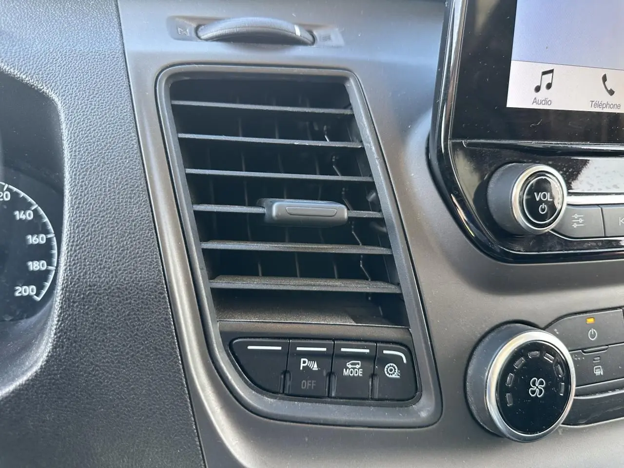 Détail de la console centrale du Ford Transit Fourgon blanc 2020, avec commandes de stationnement et ventilation.