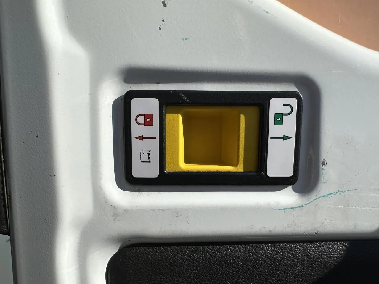 Poignée de porte intérieure jaune avec indicateurs de verrouillage sur panneau blanc du fourgon Ford Transit blanc.