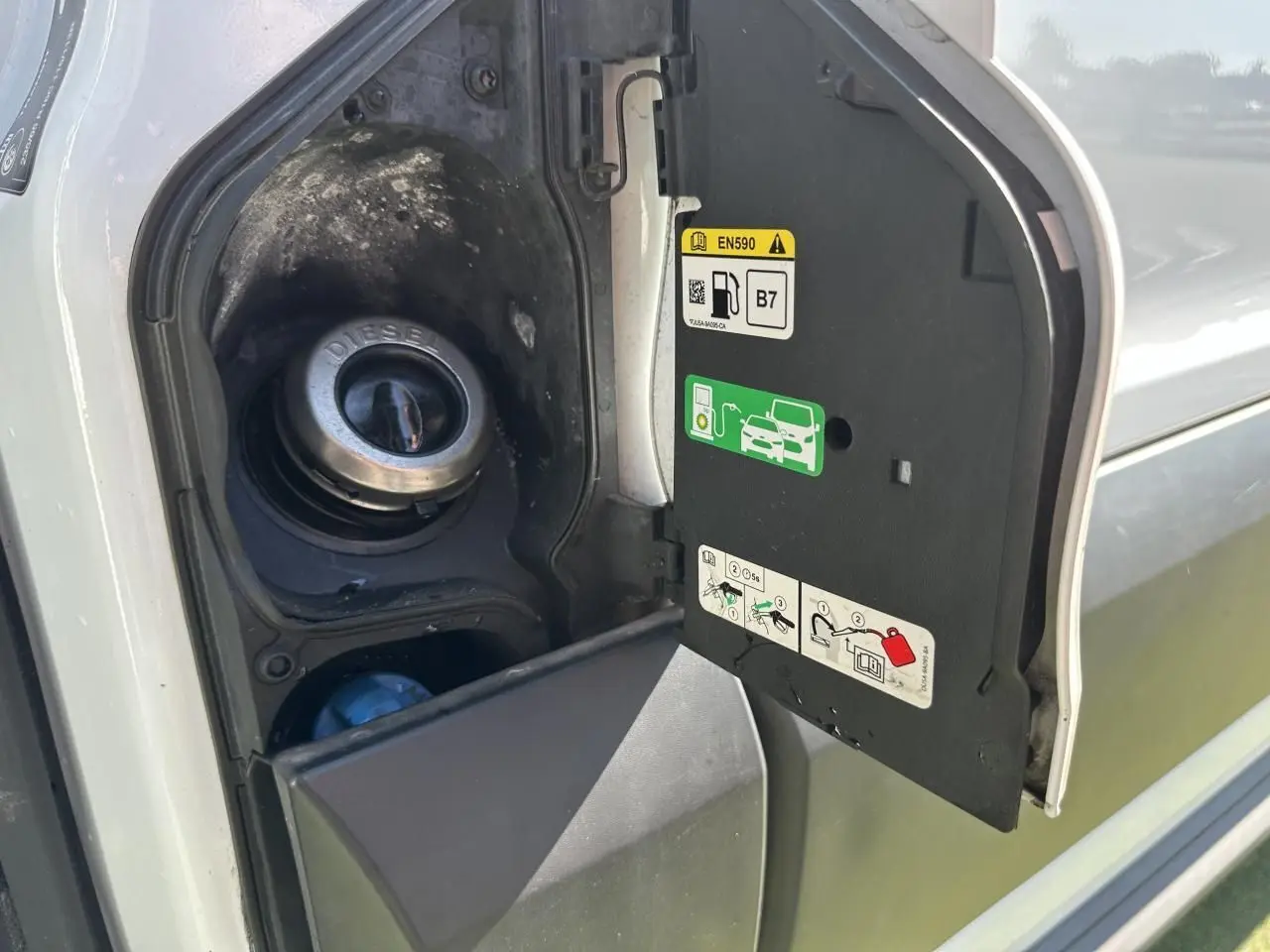 Vue rapprochée de la trappe à carburant diesel ouverte côté gauche du Ford Transit Fourgon blanc 2020.