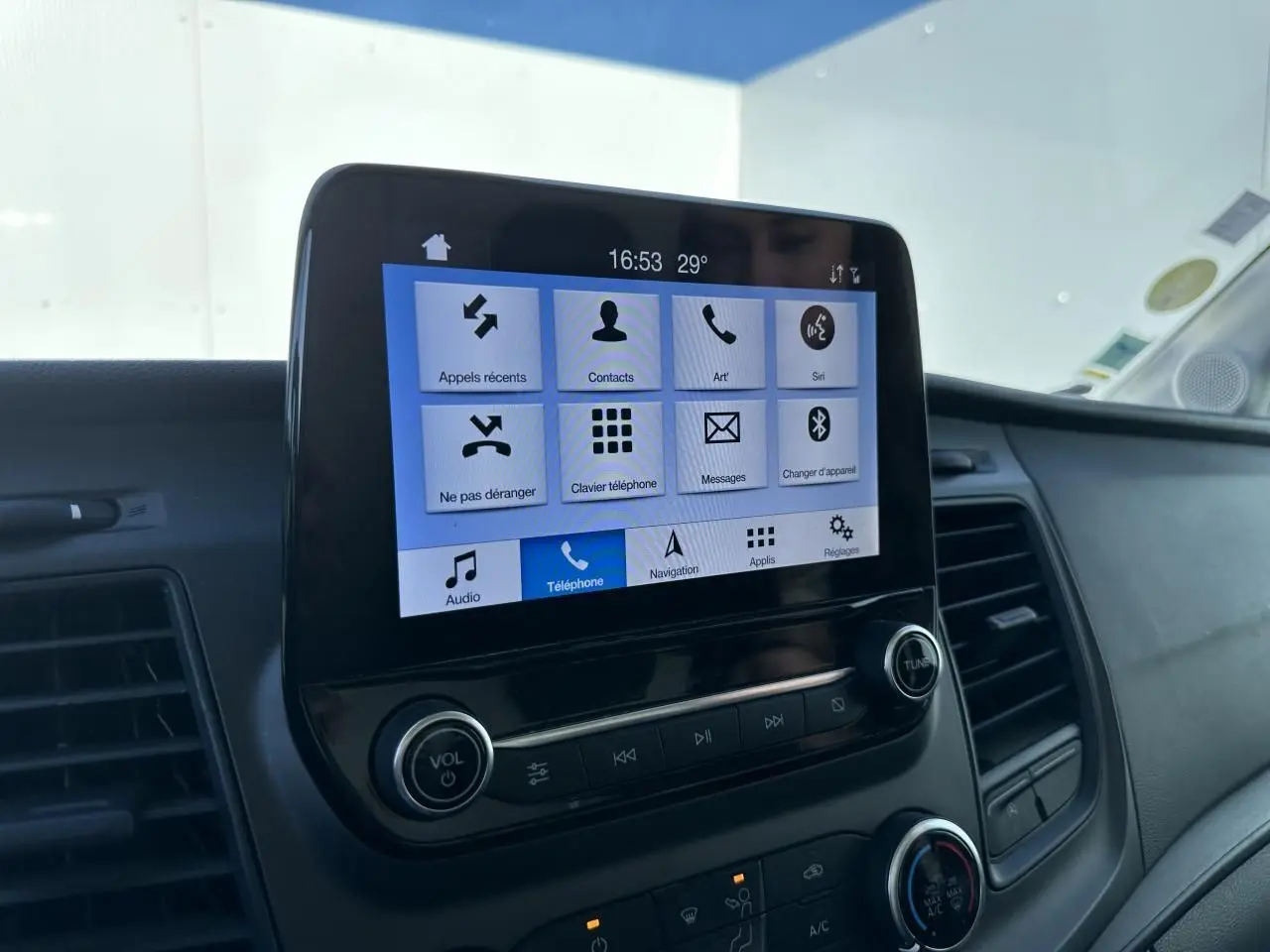 Écran tactile central du système SYNC 3 du Ford Transit Fourgon blanc, vue rapprochée du tableau de bord côté passager.