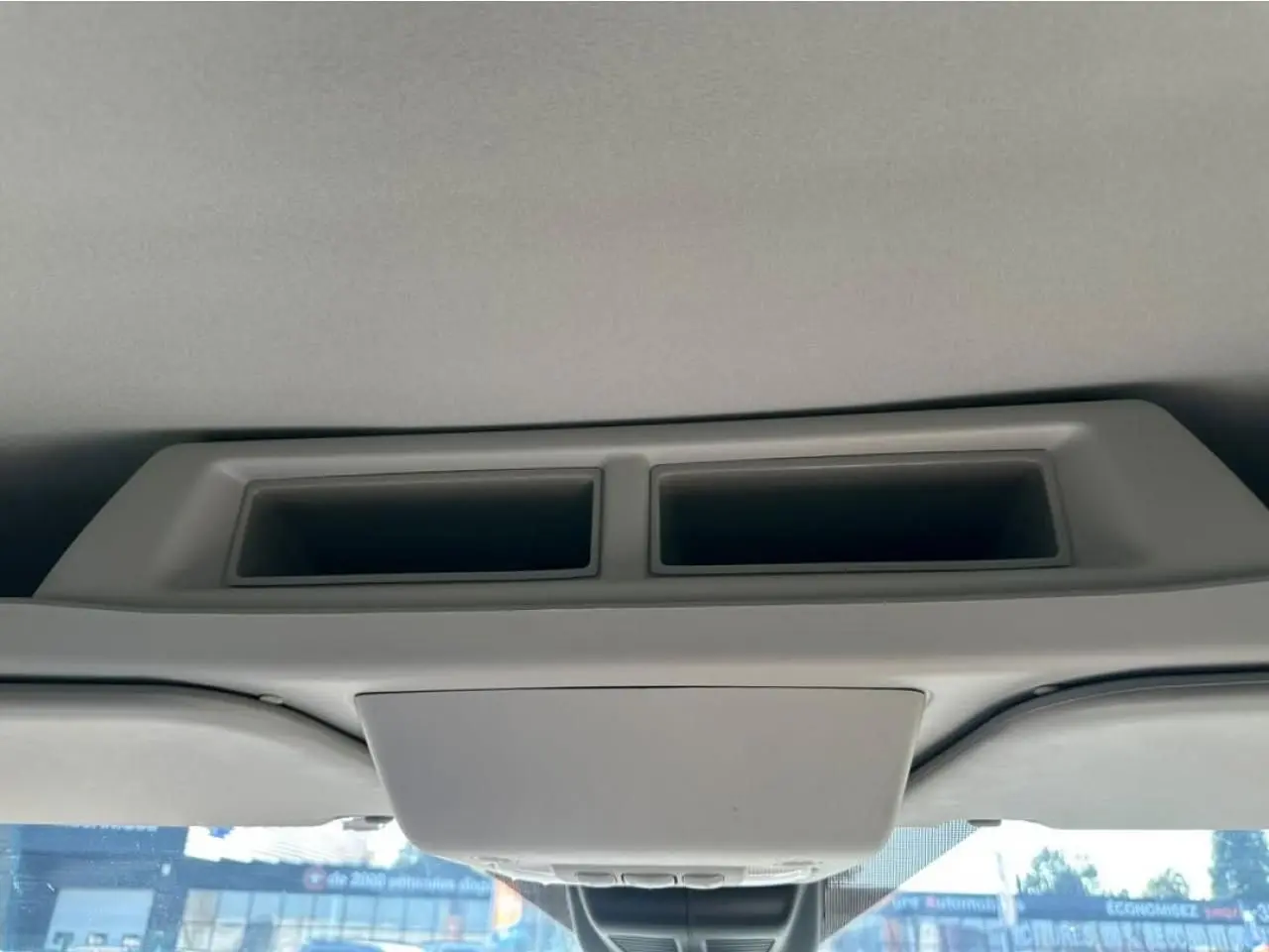 Vue intérieure du plafond cabine du Ford Transit Fourgon blanc, avec bouches d'aération et rangement intégré.