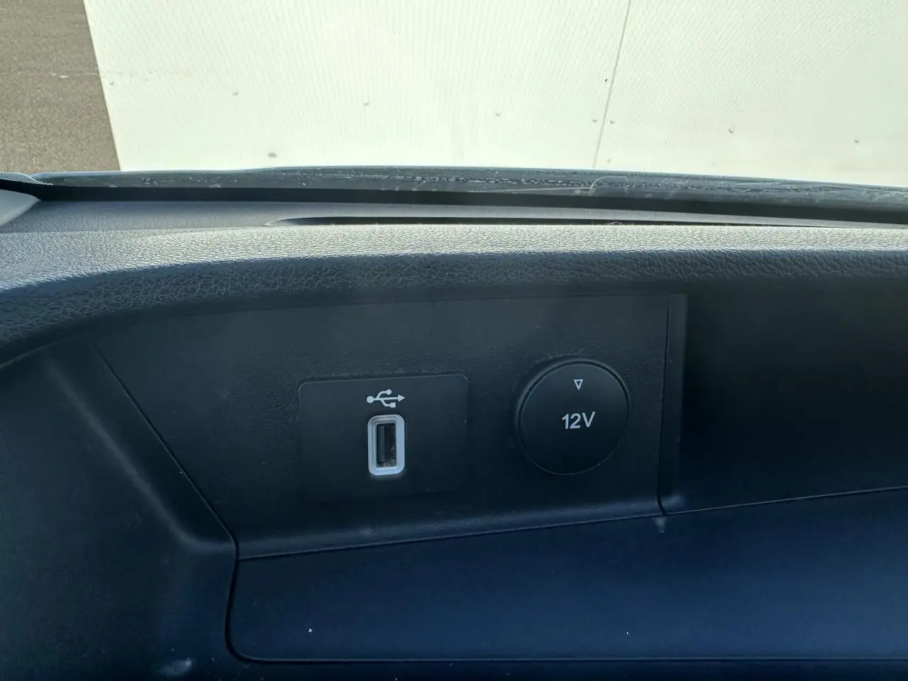 Gros plan sur la prise USB et la sortie 12V du tableau de bord noir du Ford Transit Fourgon blanc de 2020.