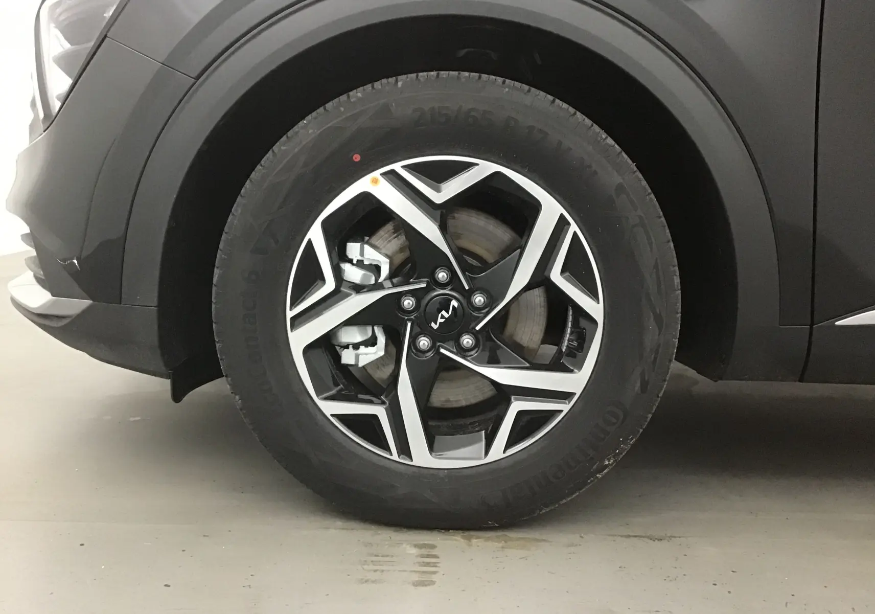 Gros plan sur la roue avant gauche du KIA SPORTAGE noir 2025, mettant en valeur la jante alliage 17 pouces au design moderne.