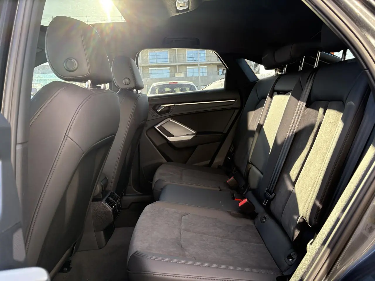 Vue intérieure côté droit des sièges arrière en tissu et cuir gris foncé de l'Audi Q3 Sportback 2025.
