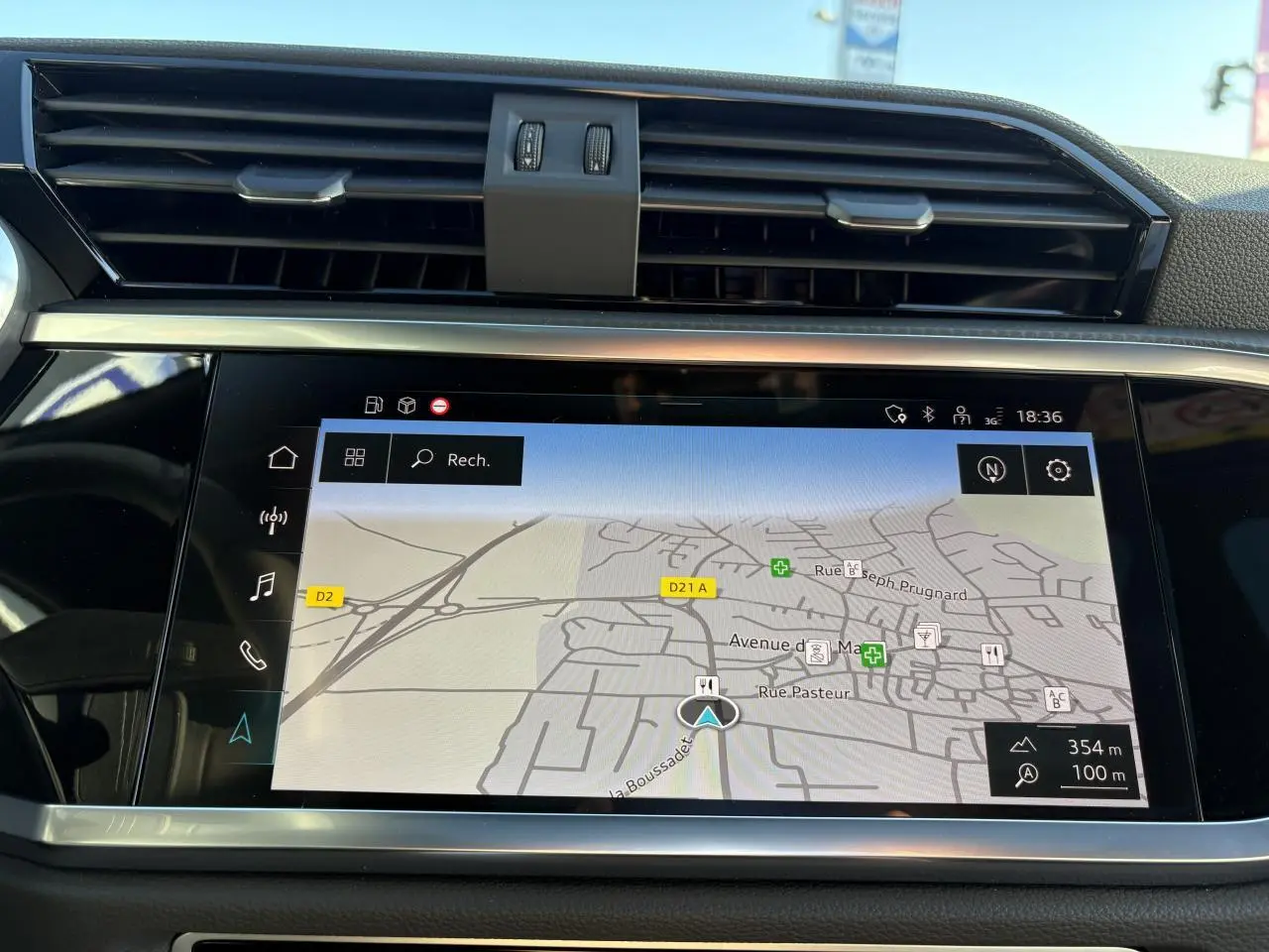 Écran tactile central affichant la navigation GPS dans l'habitacle noir de l'Audi Q3 Sportback gris Daytona.