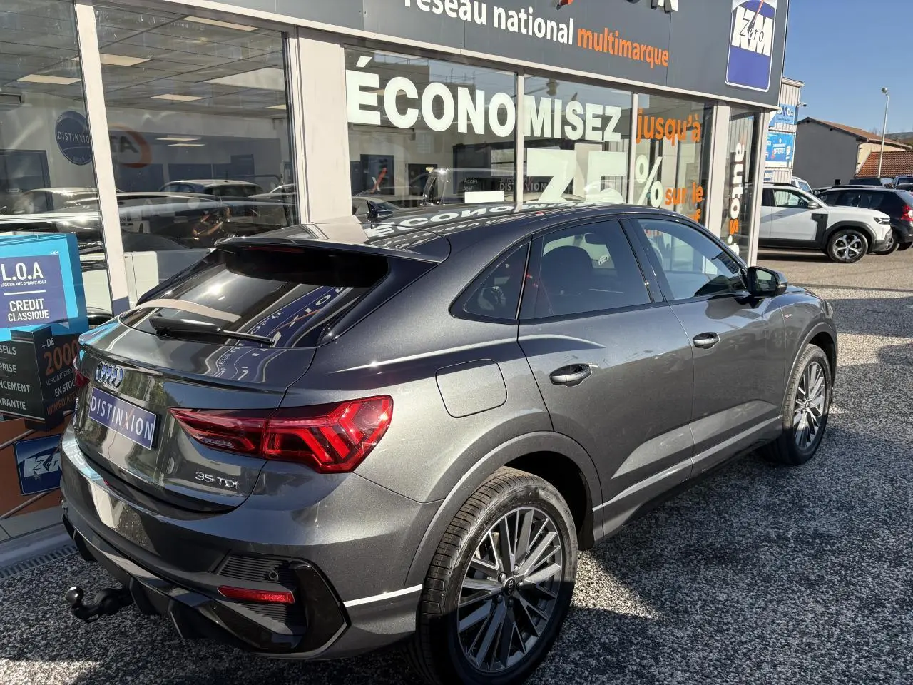 Audi Q3 Sportback gris Daytona vue 3/4 arrière droit avec jantes 20 branches et crochet d'attelage visible
