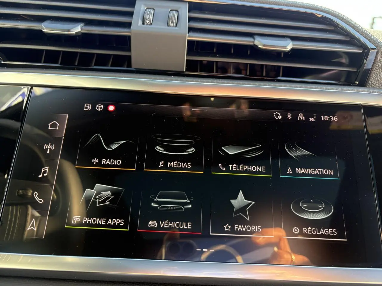 Écran tactile central de l'Audi Q3 Sportback 2025 affichant les menus multimédia et navigation, intérieur moderne noir.