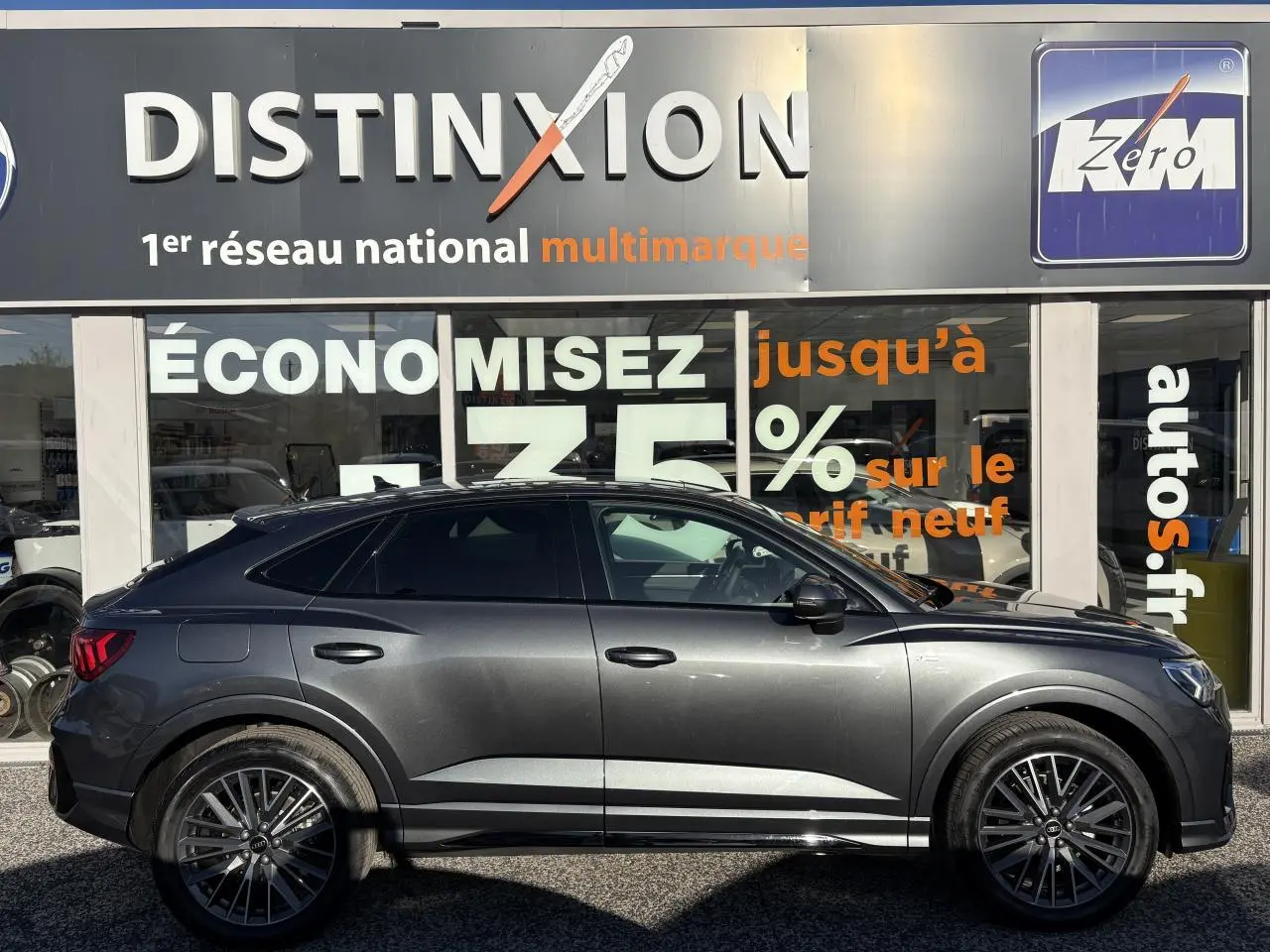 Profil côté gauche d'un Audi Q3 Sportback gris Daytona 2025 avec jantes 20 branches et vitres surteintées.