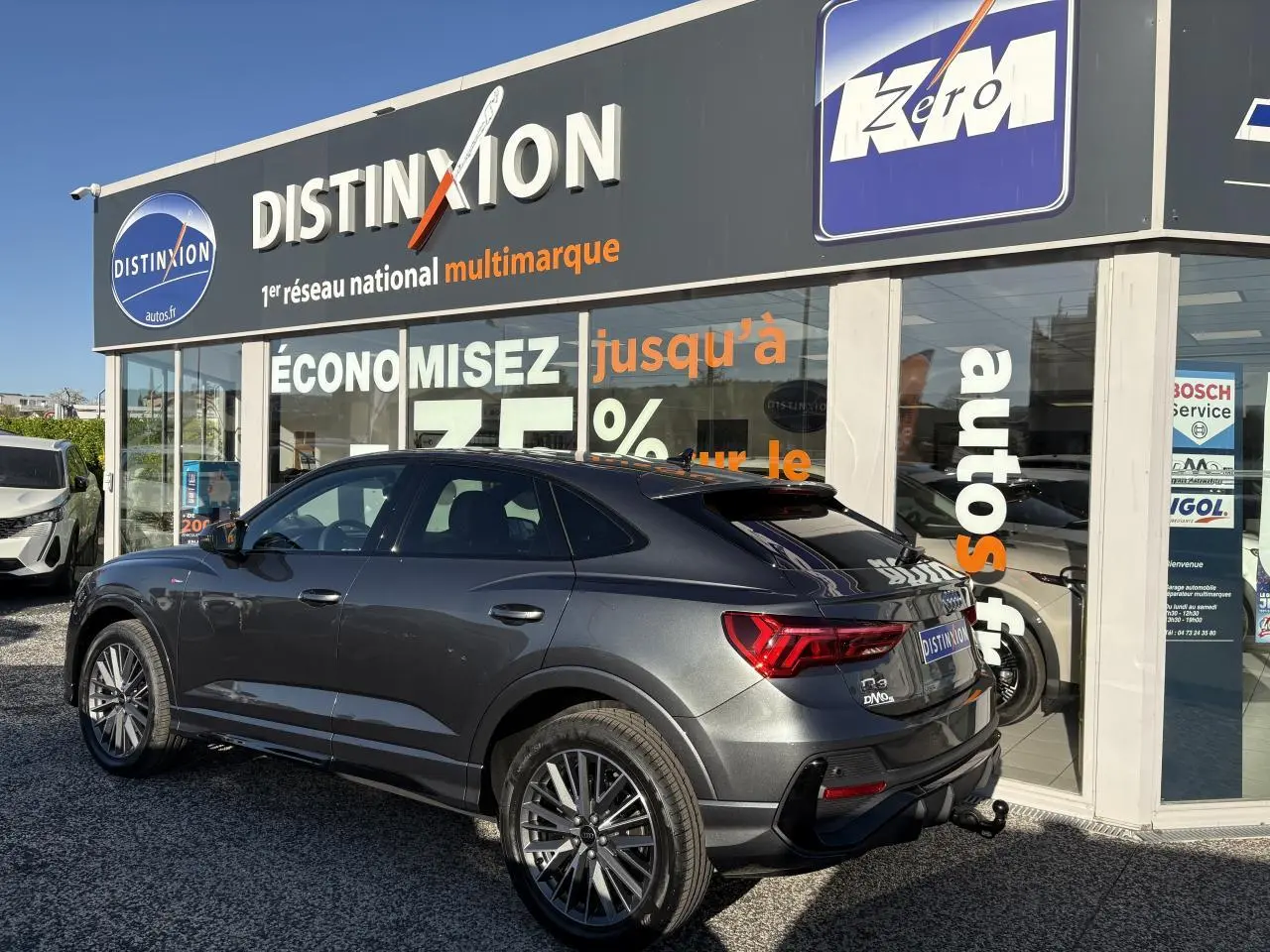 Audi Q3 Sportback gris Daytona vue 3/4 arrière droit avec jantes 20 branches et crochet d'attelage visible