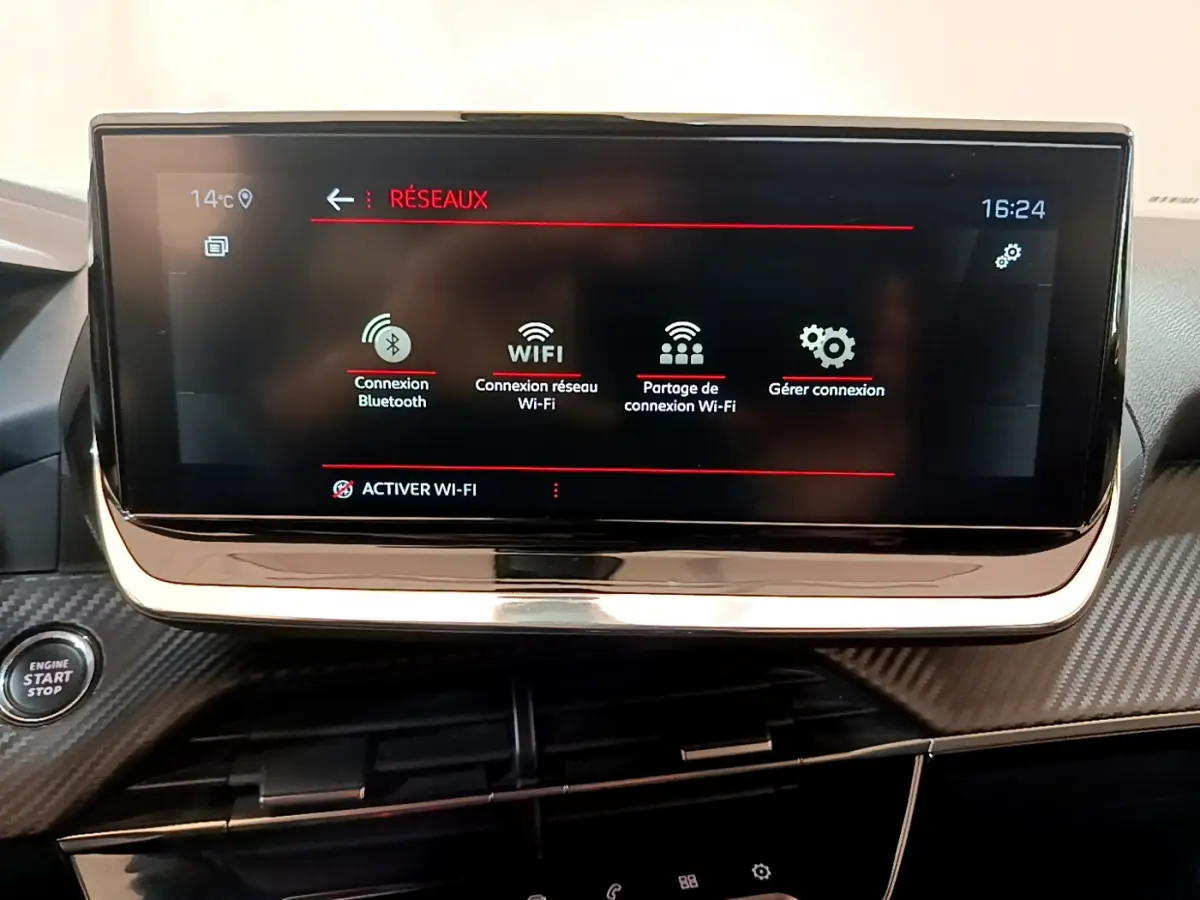 Écran tactile 10 pouces du tableau de bord du Peugeot 2008 gris clair, avec menu réseaux et bouton démarrage visible.