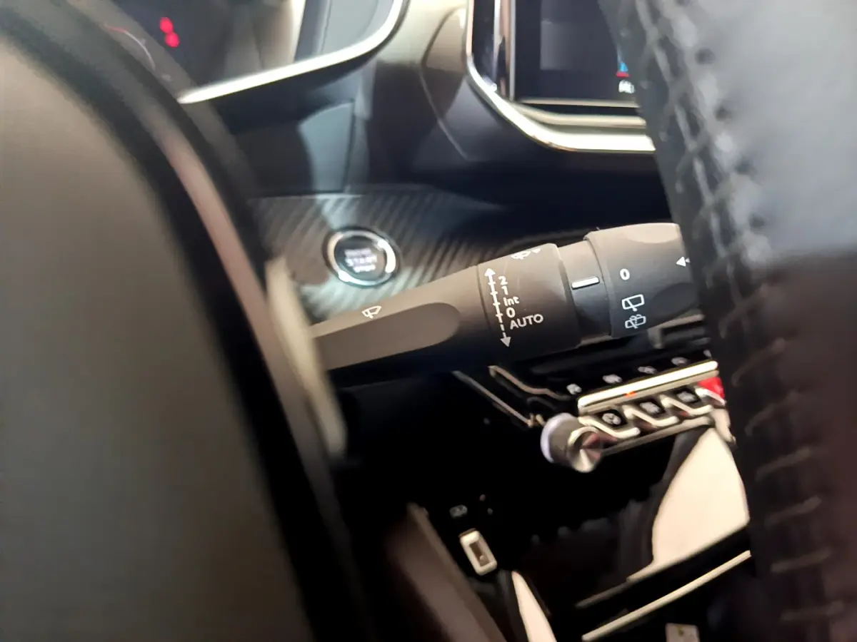 Gros plan sur la manette d'essuie-glace côté gauche du tableau de bord gris carbone d'un Peugeot 2008 2021.