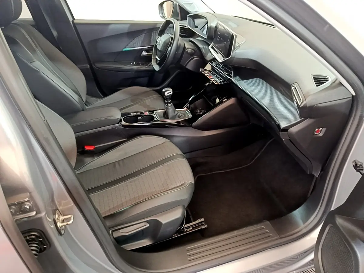 Vue intérieure côté conducteur du Peugeot 2008 gris clair 2021 avec tableau de bord moderne et écran tactile central.