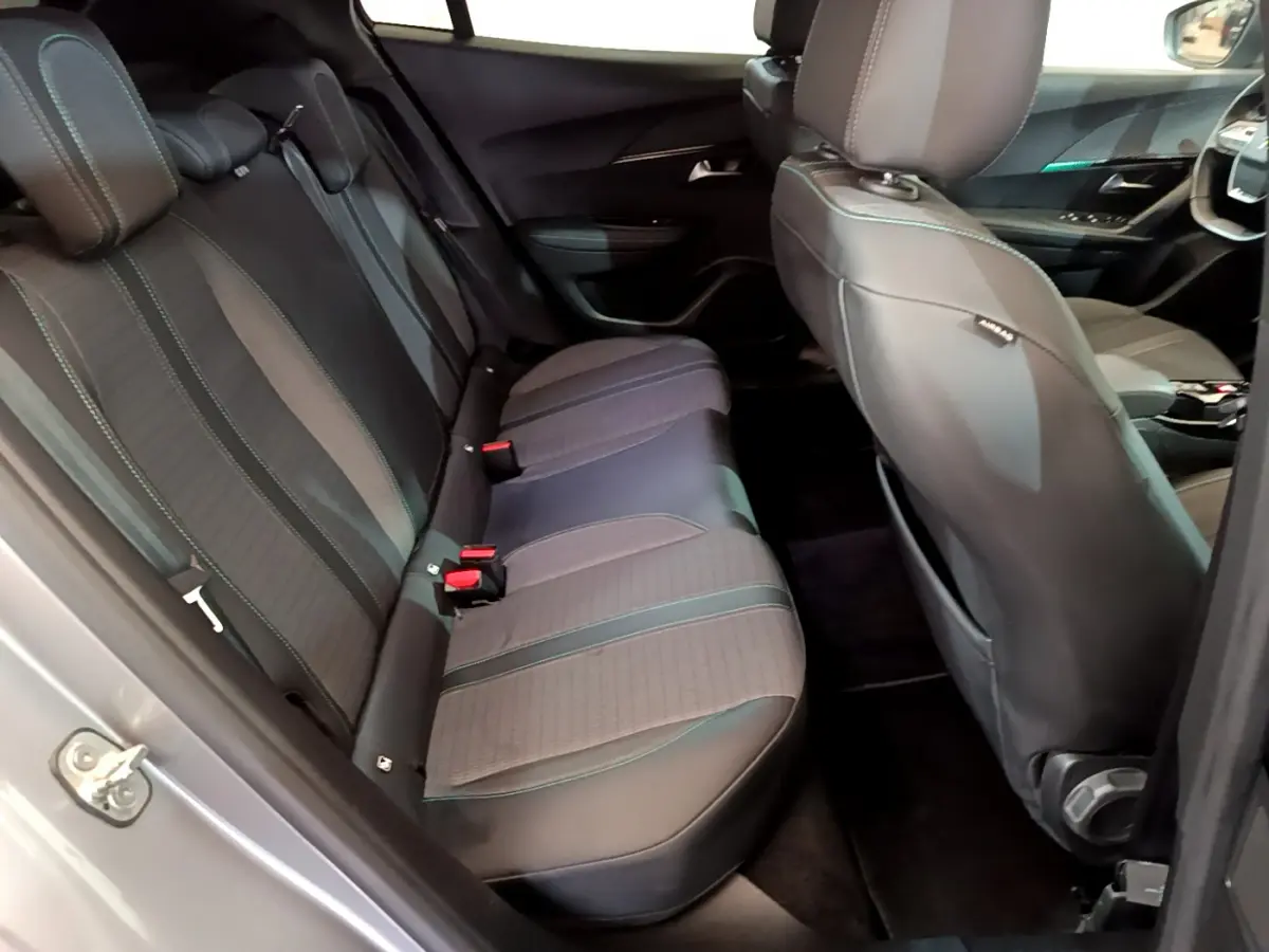 Vue intérieure côté gauche montrant la banquette arrière et les sièges avant du Peugeot 2008 gris clair 2021.