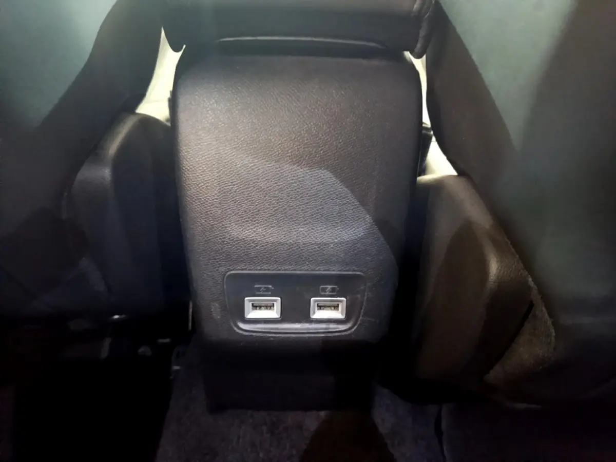 Prise double USB arrière noire entre les sièges dans l'habitacle du Peugeot 2008 gris clair 2021.