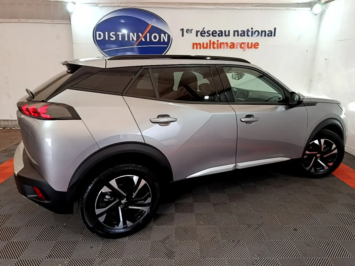 Peugeot 2008 gris clair vue de profil côté gauche, avec jantes noires et toit noir contrastant.