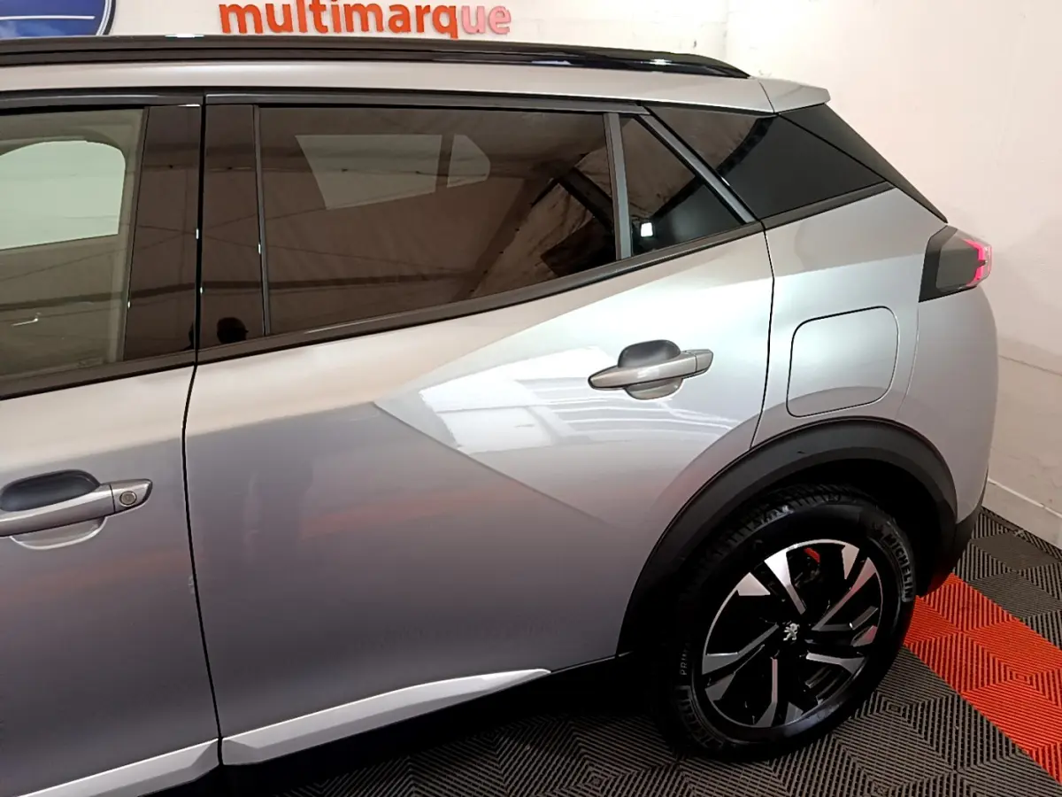 Vue côté droit arrière du Peugeot 2008 gris clair avec jante noire et poignées de porte intégrées.