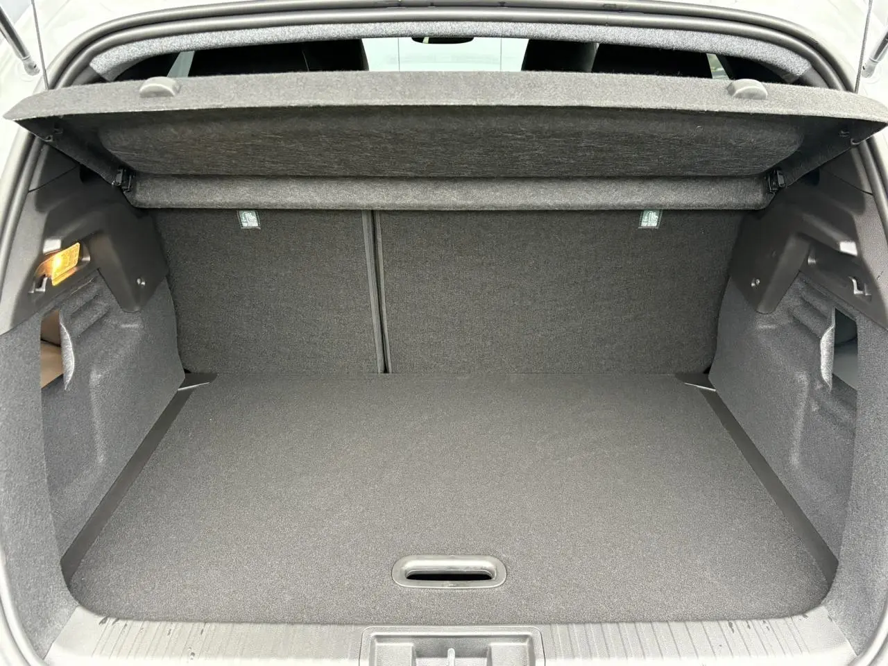 Coffre ouvert du Renault Captur blanc nacré 2025, vue intérieure montrant l’espace de rangement et la tablette arrière.