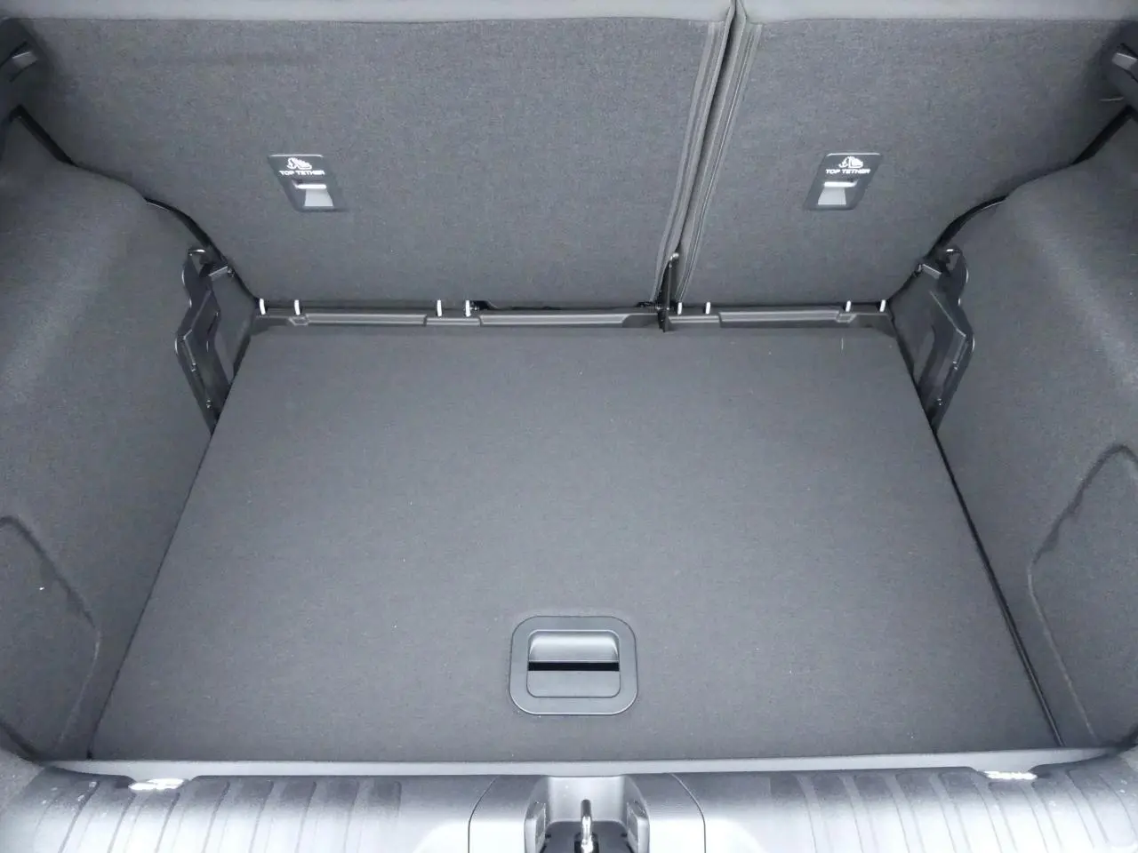 Coffre spacieux vu de dessus du Ford Puma 2025 gris métallisé avec plancher plat et compartiment de rangement.