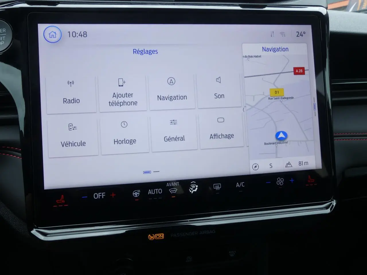 Écran tactile SYNC 4 de la Ford Puma 2025 affichant le menu Réglages et la navigation, intérieur noir avec surpiqûres rouges.