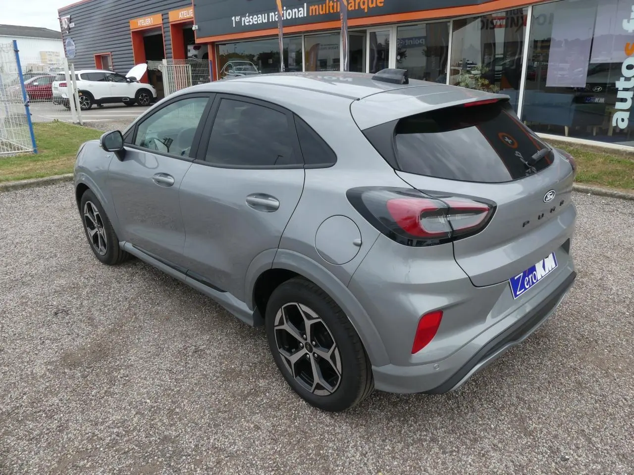 Ford Puma 2025 gris métallisé vue 3/4 arrière droit, jantes alliage 17 pouces et vitres surteintées.