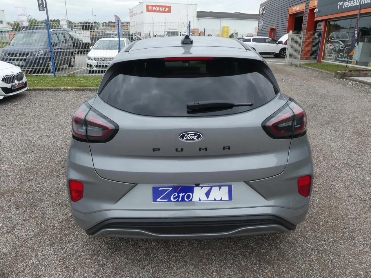 Vue arrière d'un Ford Puma gris métallisé 2025 avec vitrage arrière surteinté et logo PUMA visible.